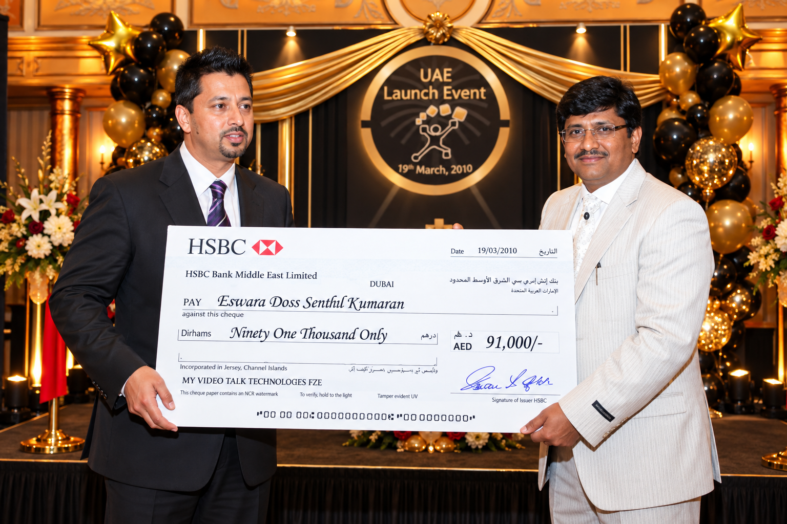 Sonu Sandhu and Dr. E. Senthil Kumaran holding the signed HSBC cheque for AED 91,000 on stage at the UAE Launch Event, 19 March 2010